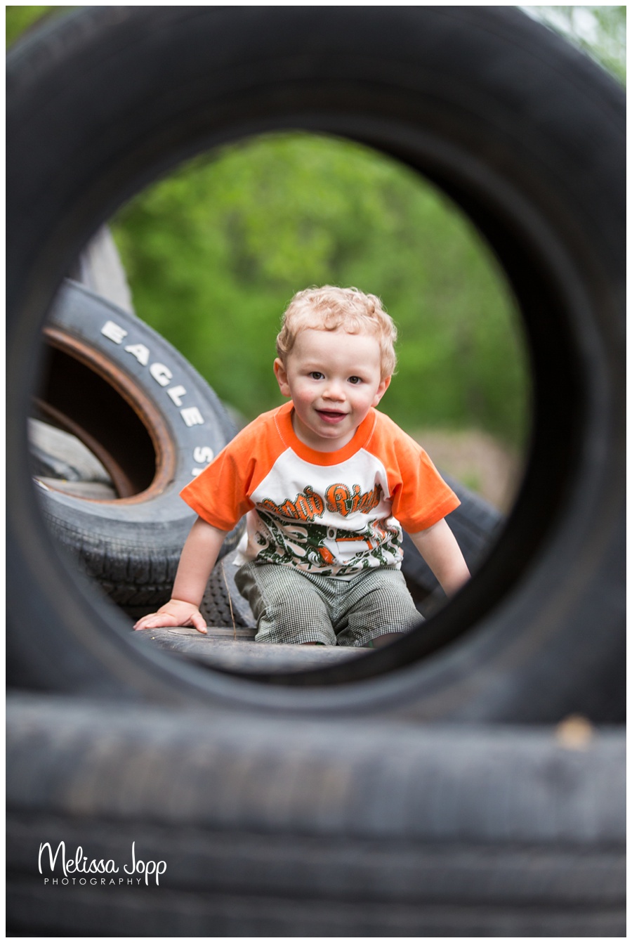 little boy looking through tire waconia mn child photographer